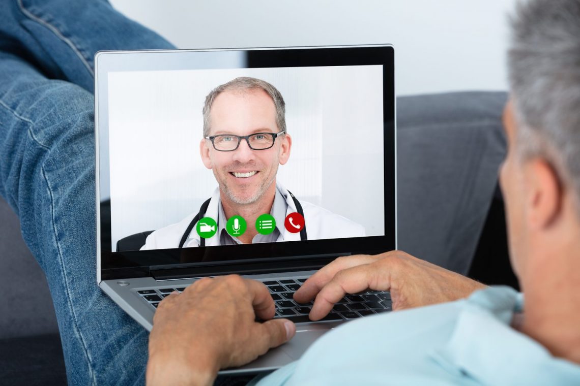 Man Videoconferencing With Doctor On Laptop
